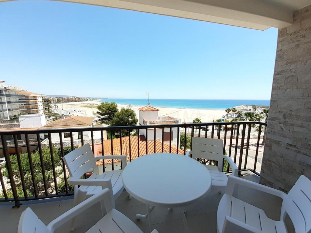 托里代巴拉Apartamentos Dins Mar Apto. 10的阳台上配有白色的桌椅,享有海景