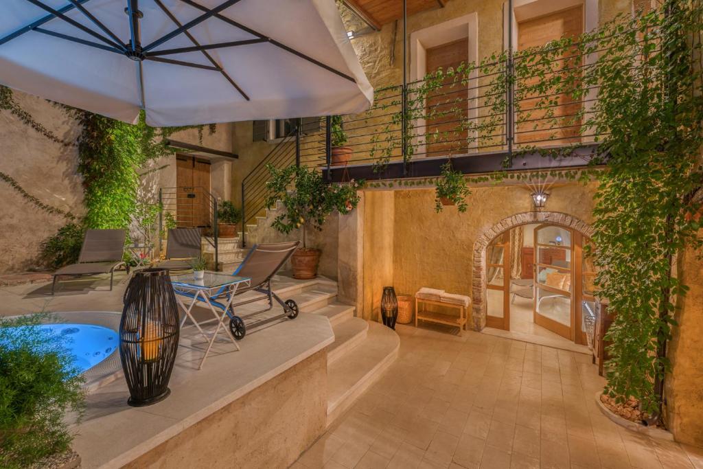 加尔尼亚诺Corte Alma Spa and Luxury Home的一个带遮阳伞和热水浴池的户外庭院