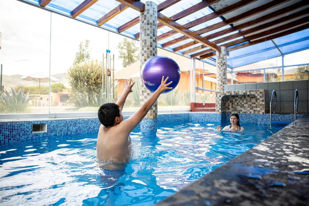 Yanque特拉迪逊科尔卡酒店的男孩在游泳池玩球