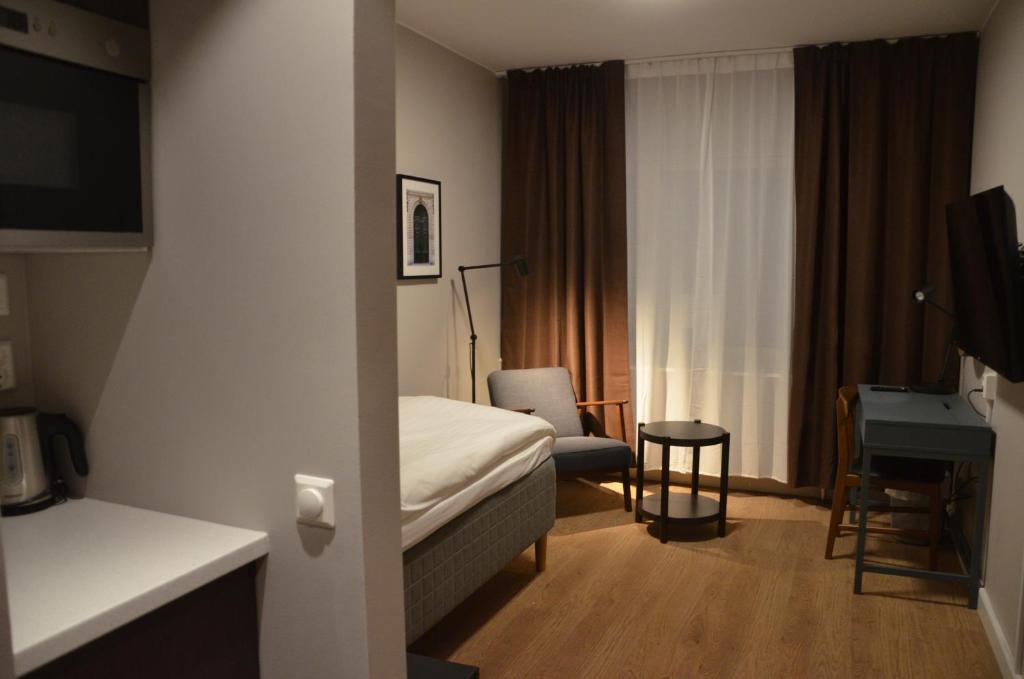 厄斯特松德Hotell Zäta Longstay的酒店客房配有一张床、一把椅子和一张书桌