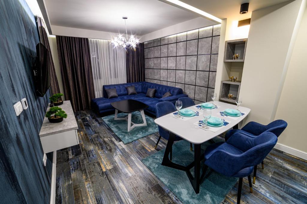 比耶利纳Apartmani Milanovic的客厅配有桌子和蓝色椅子