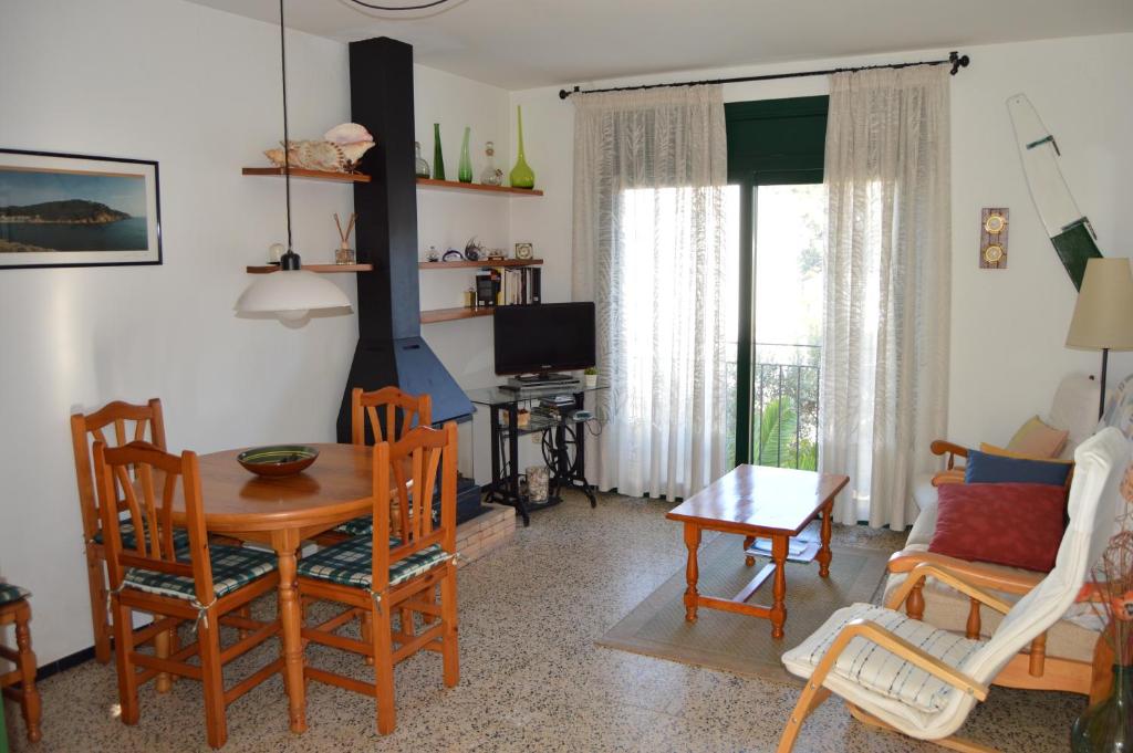 塔马留La Caseta的客厅配有桌椅和电视。