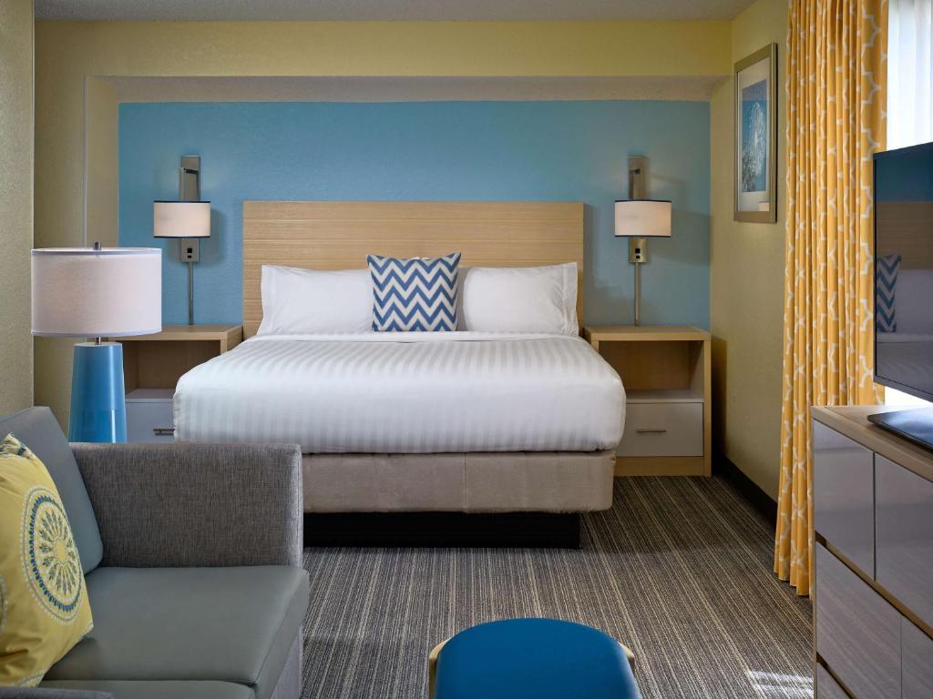 伯灵顿伯灵顿圣淘沙集团酒店的一间卧室配有一张床、一张沙发和一把椅子