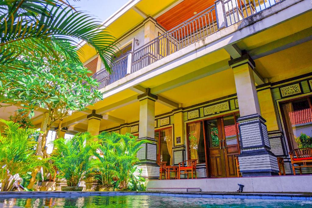坎古阿迪旅馆的一座黄色的建筑,前面有一个游泳池