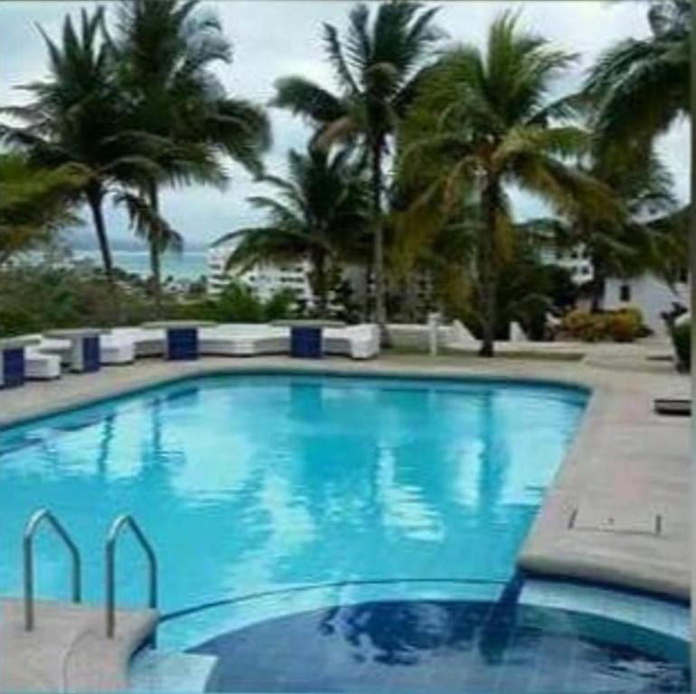 赛姆Casa completa SAME Casa Blanca的一座种植了棕榈树和大海的大型蓝色游泳池