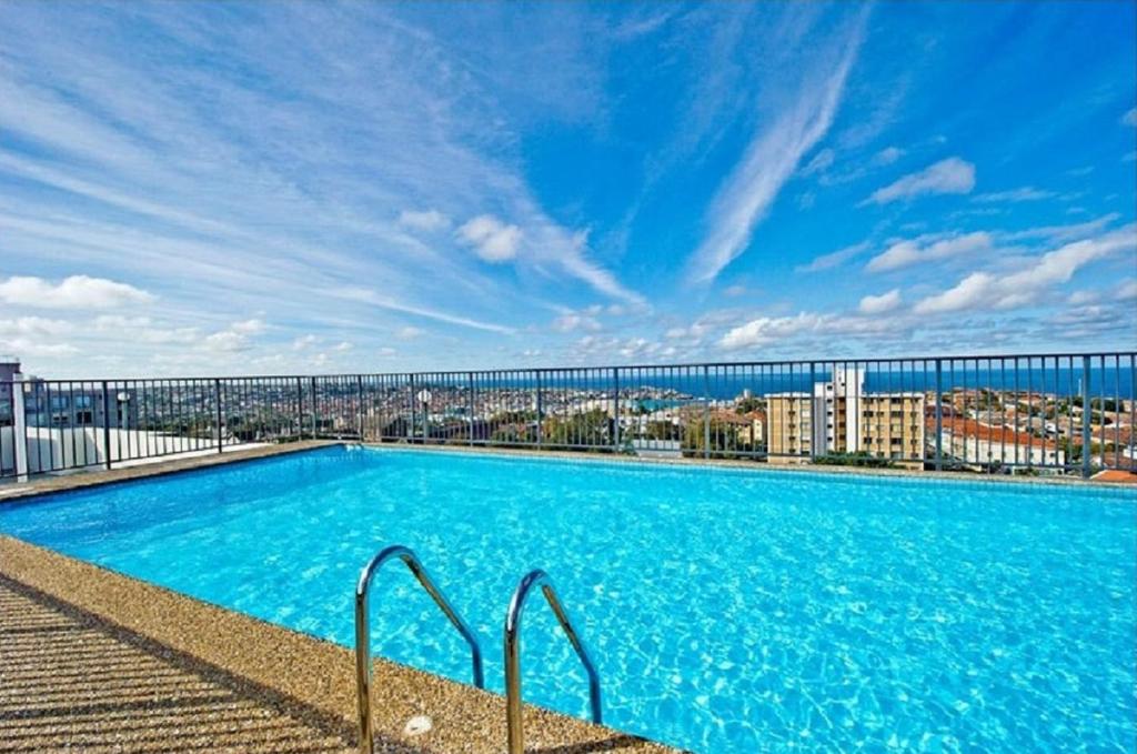 悉尼HolidayRento Bondi Beach Ocean View Rooftop Pool的一座带桥的建筑顶部的大型游泳池