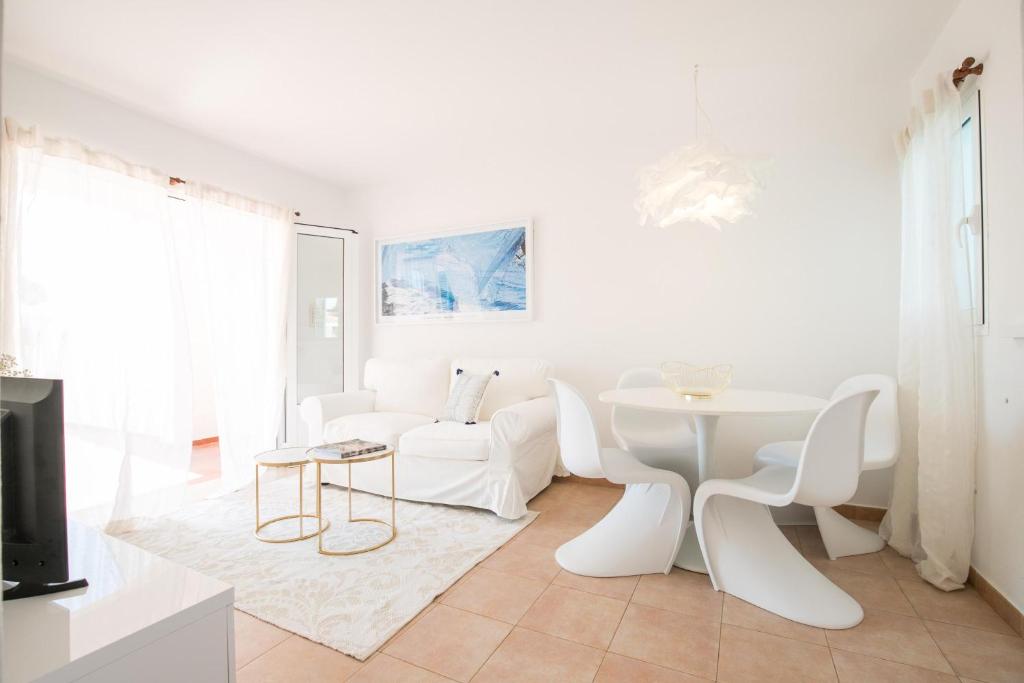 卡拉加尔达纳Apartamentos Annabel's 2-3 HABITACIONES的白色的客厅配有白色的桌子和椅子