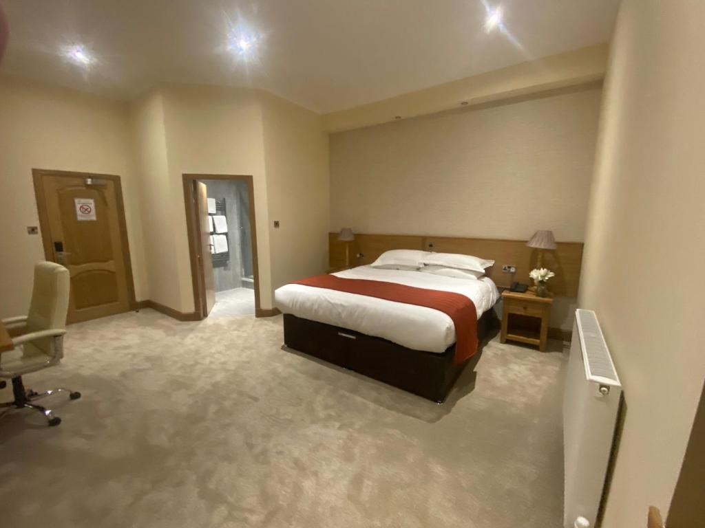 邓弗姆林城市酒店的一间卧室配有一张床、一张桌子和一把椅子
