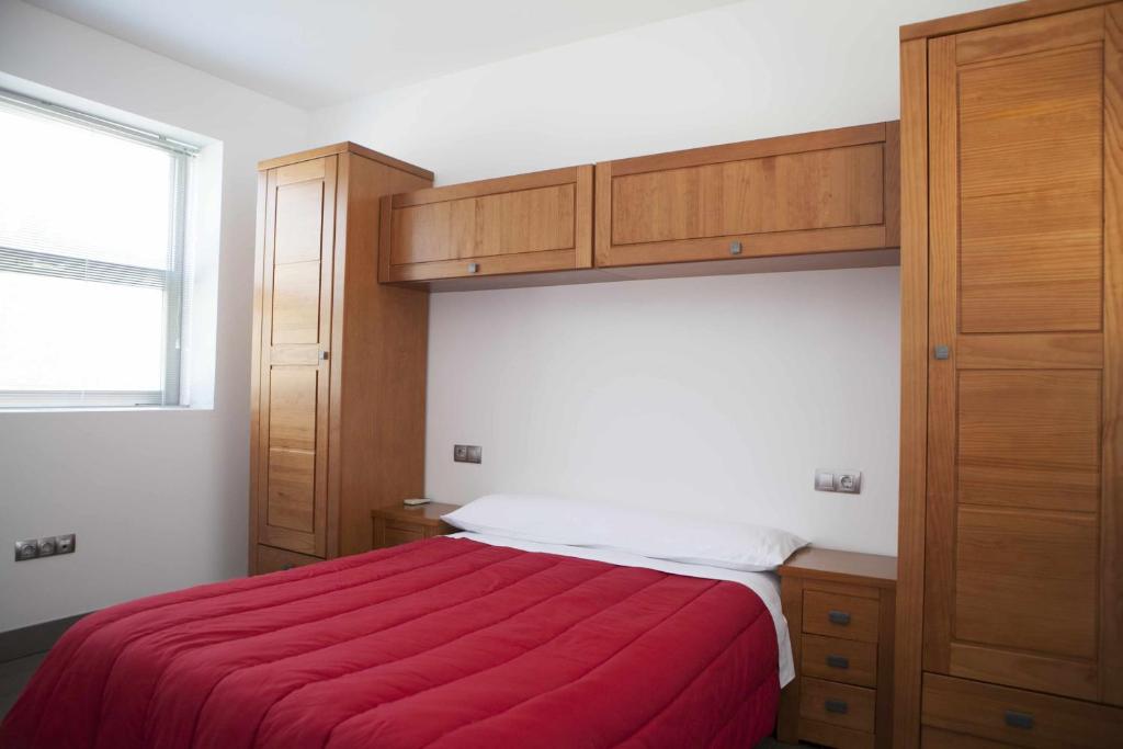 奥尔维拉维贡威亚威尔德拉谢拉度假屋的一间卧室配有一张带红色毯子的床