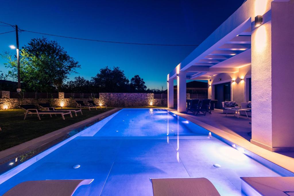 (( Litherés ))Arivallos Villa & SPA with Sauna and Wine Cellar的夜间房子后院的游泳池