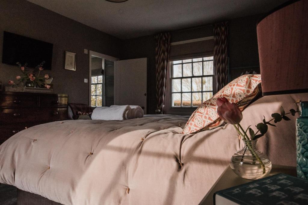 格洛斯特The Naight House的一间卧室,配有一张床和一个花瓶