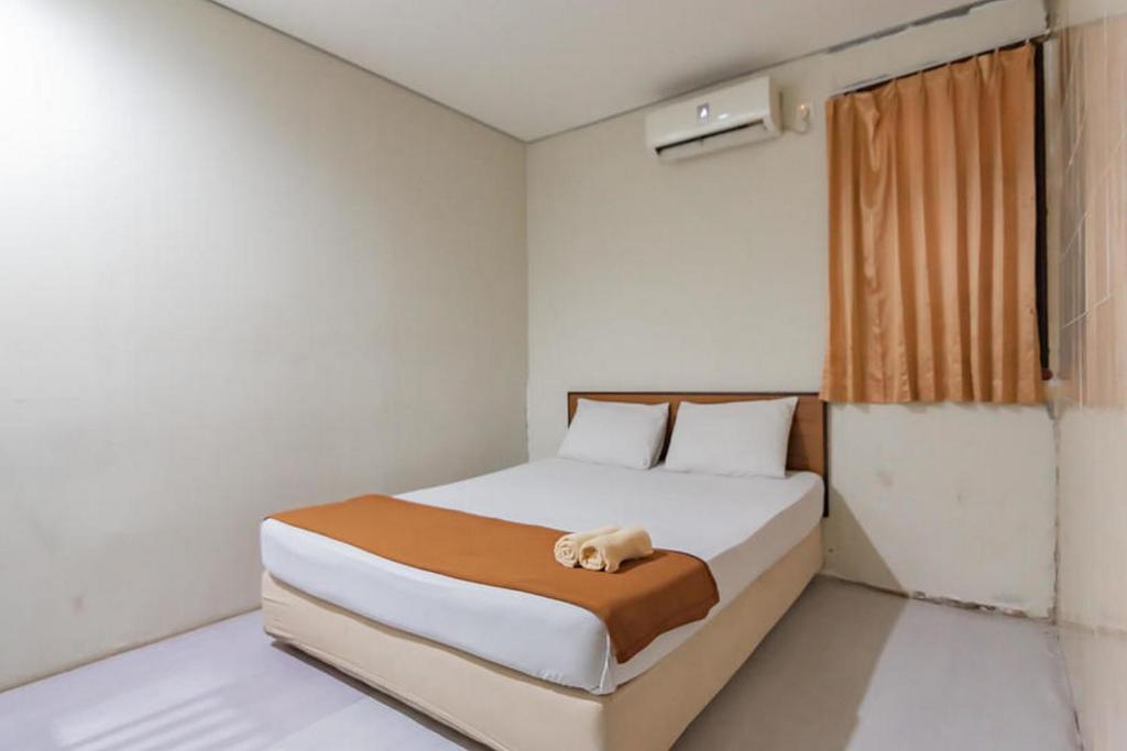 巴厘巴板Mahkota Intan Syariah Balikpapan RedPartner的一间卧室配有一张床,床上有毛巾