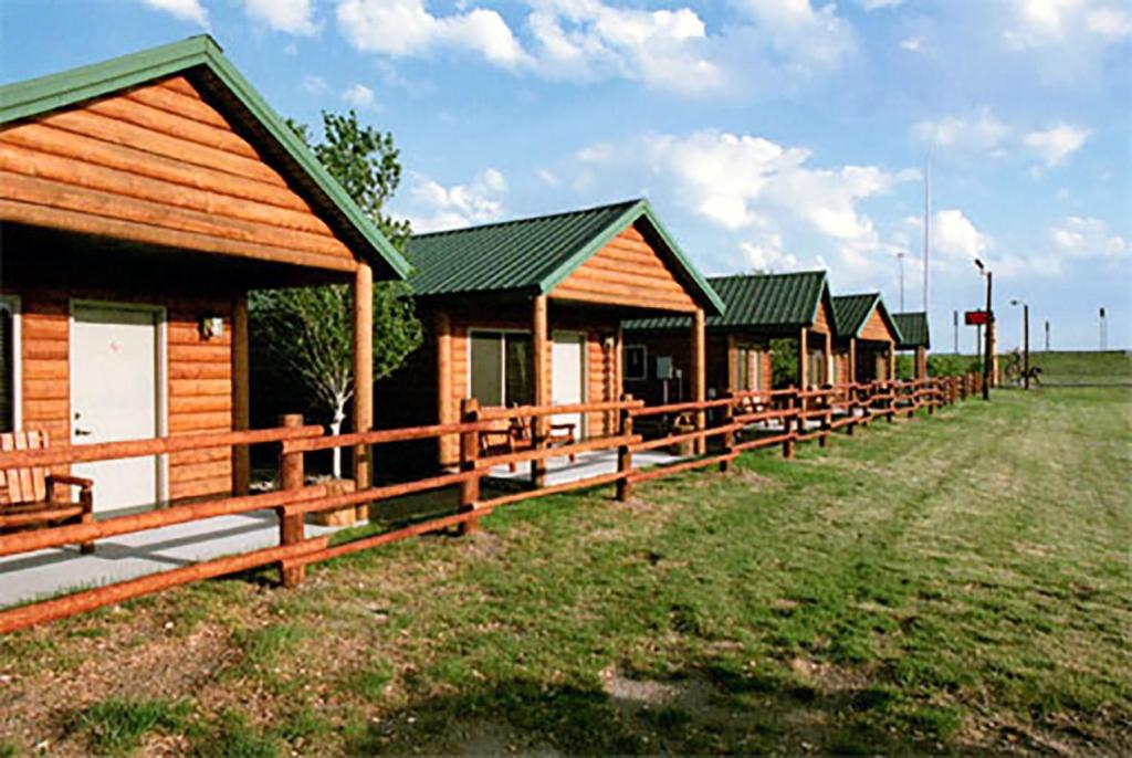 沃尔Badlands Frontier Cabins的田野上的一排木结构建筑