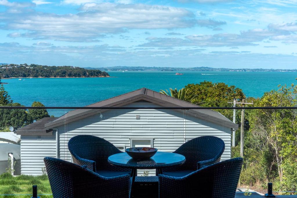 欧尼罗亚Luna Cottage. Stunning ocean views on Waiheke的享有水景的天井配有桌椅