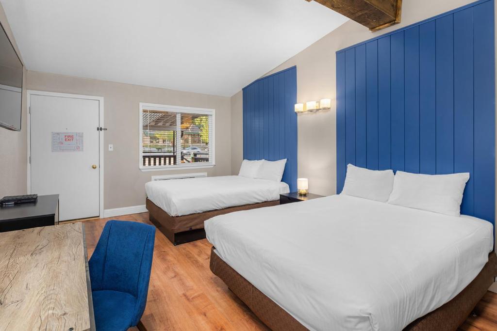 塔霍城The Inn at Boatworks, Lake Tahoe的酒店客房设有两张床和蓝色的墙壁。