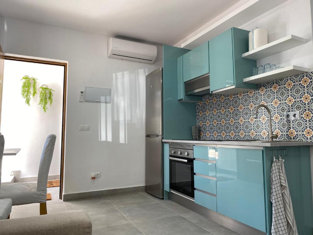 马贝拉Morgan apartamentos Marbella centro的厨房配有蓝色橱柜和炉灶。