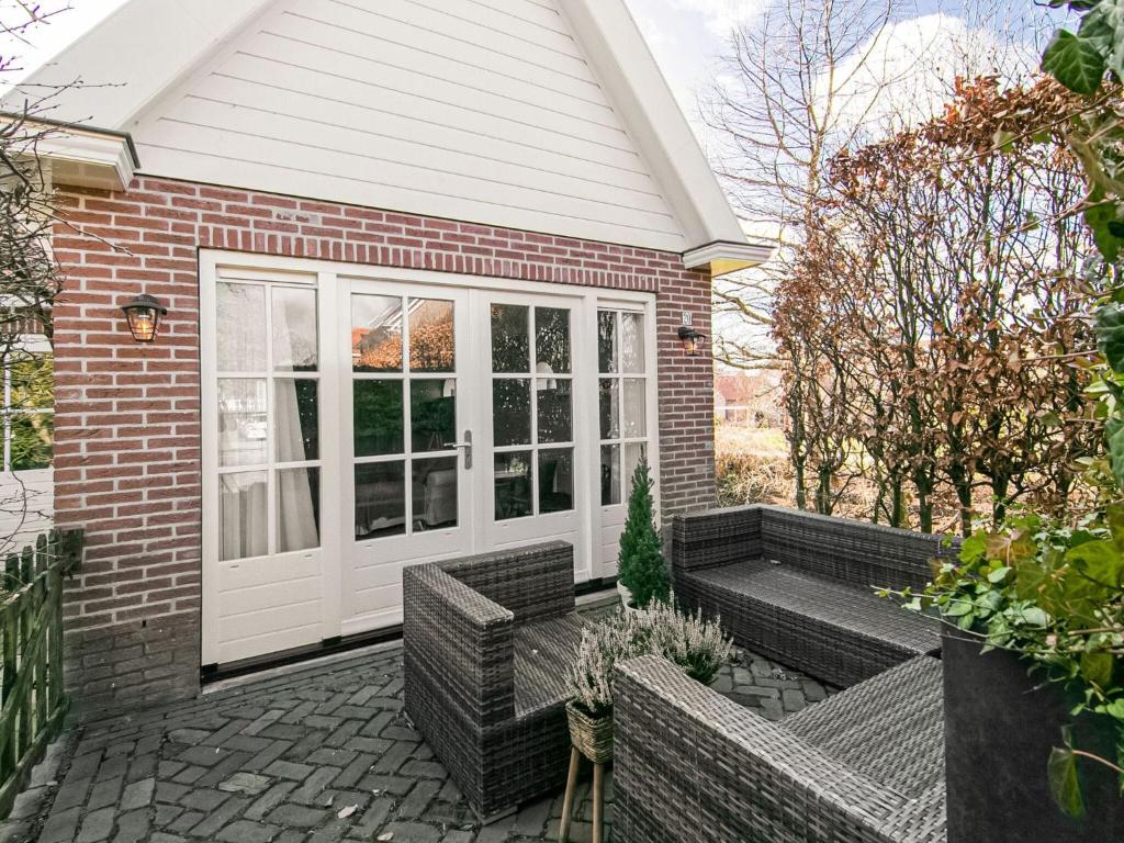 梅登布利克Appealing Holiday Home in Medemblik with Garden的砖屋,带藤椅的庭院
