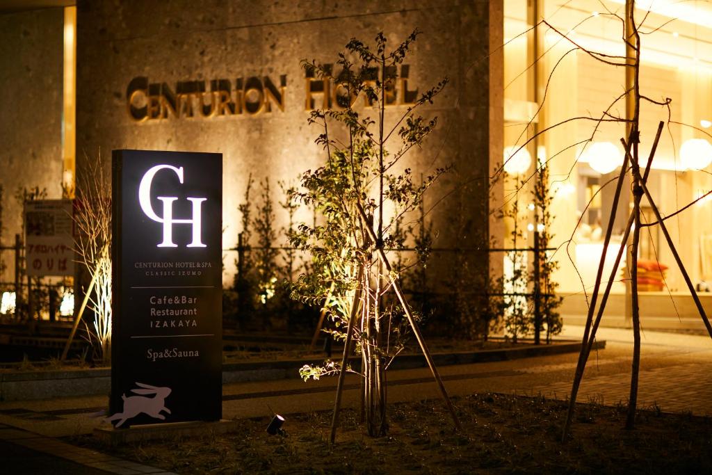 出云市The Centurion Hotel & Spa Classic Izumo的夜间在建筑物前的标志