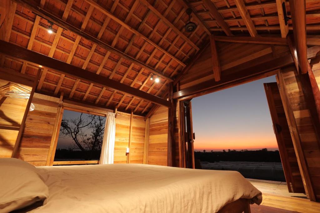 Phu YenTODO Farm - Organic Farming & Retreat的一间卧室设有一张床和一个大窗户