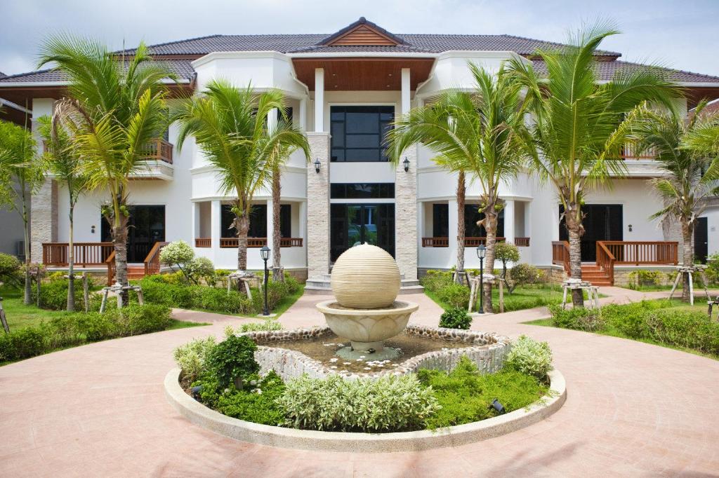 拉威海滩Rawai Grand House -SHA Plus的建筑物前方有喷泉的建筑物