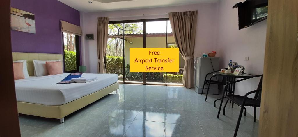 奈扬海滩司隶纳帕普吉岛度假村 的一间卧室,配有一张床和一个可阅读免费机场接送服务的标志