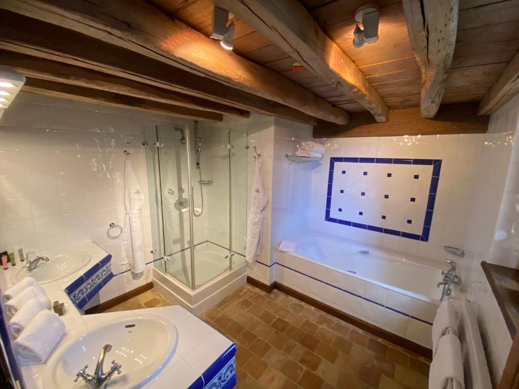 萨维尼莱博恩哈姆雷特巴普伦酒店的浴室配有2个盥洗盆、淋浴和浴缸。