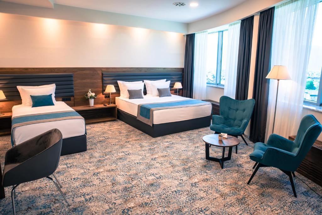 萨拉热窝拉顿广场酒店的酒店客房,配有两张床和两把椅子