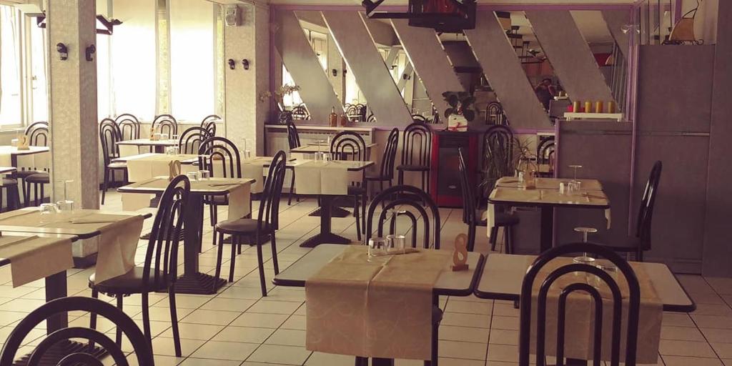 卡伦诺贝拉维斯塔比萨店及旅馆的一间在房间内配有桌椅的餐厅