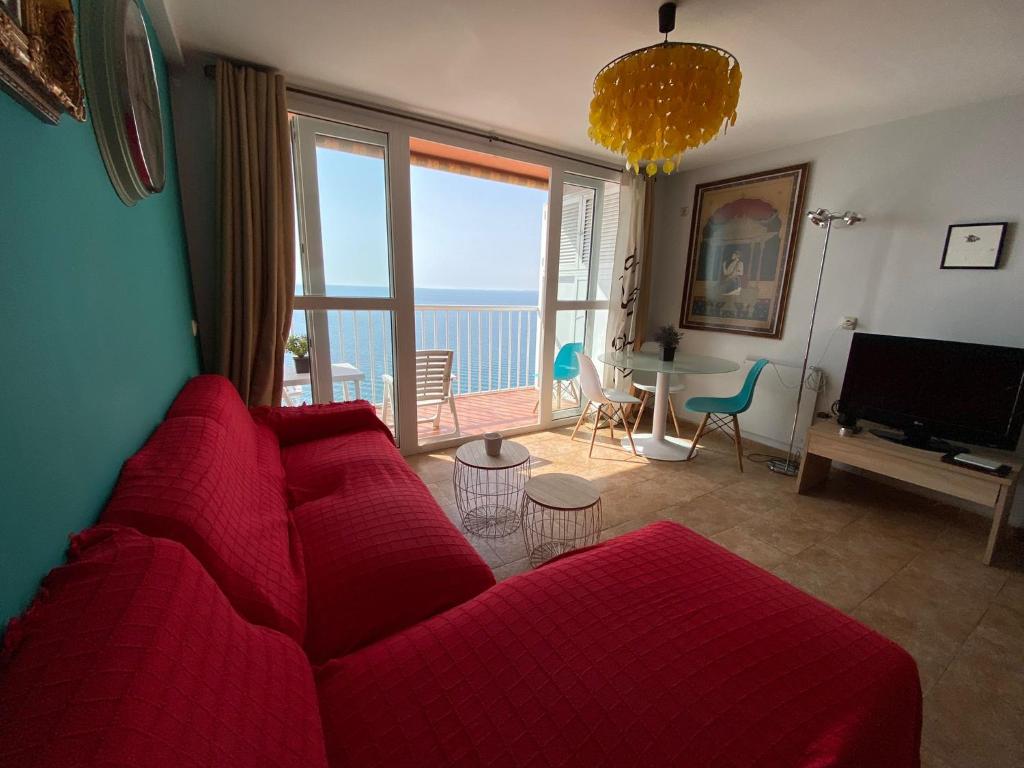 阿尔么丽亚Apartamento Almería Playa de San Miguel - Zapillo的客厅配有红色沙发,享有海景