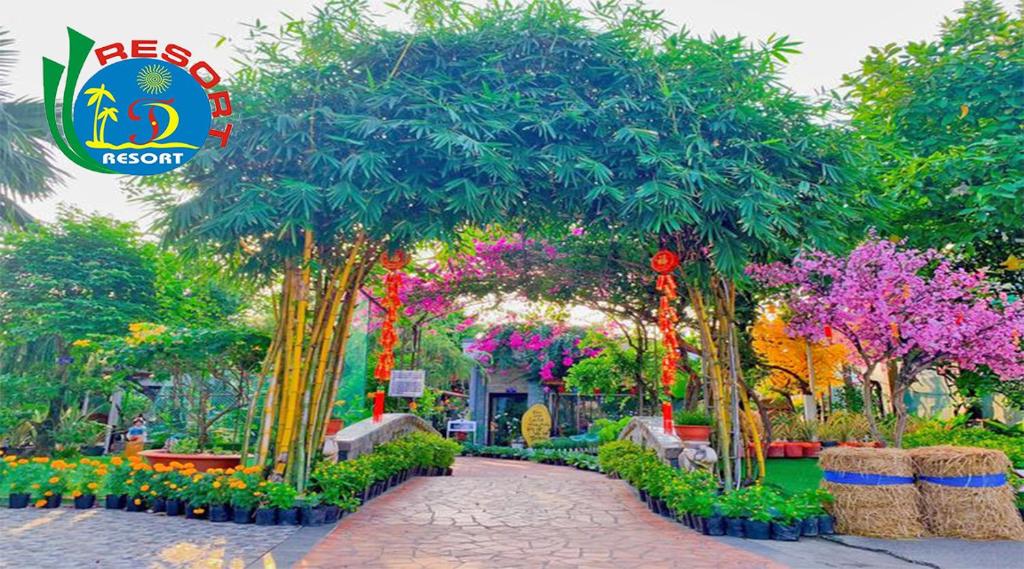 芹苴天逸酒店的种有树木和鲜花的花园以及步道