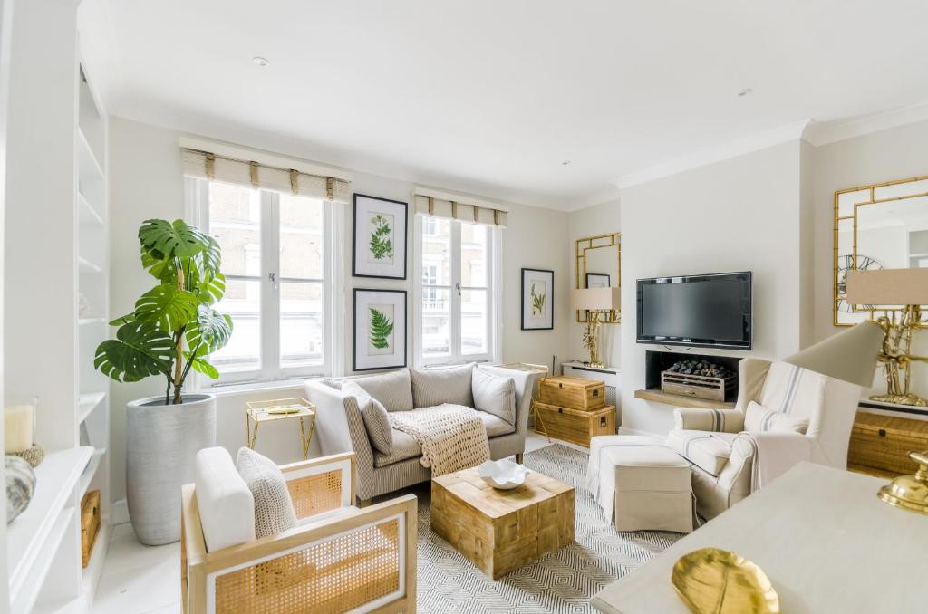伦敦JOIVY Elegant 2-bed, 2 bath flat with private terrace in South Kensington, close to tube的客厅配有白色家具和平面电视