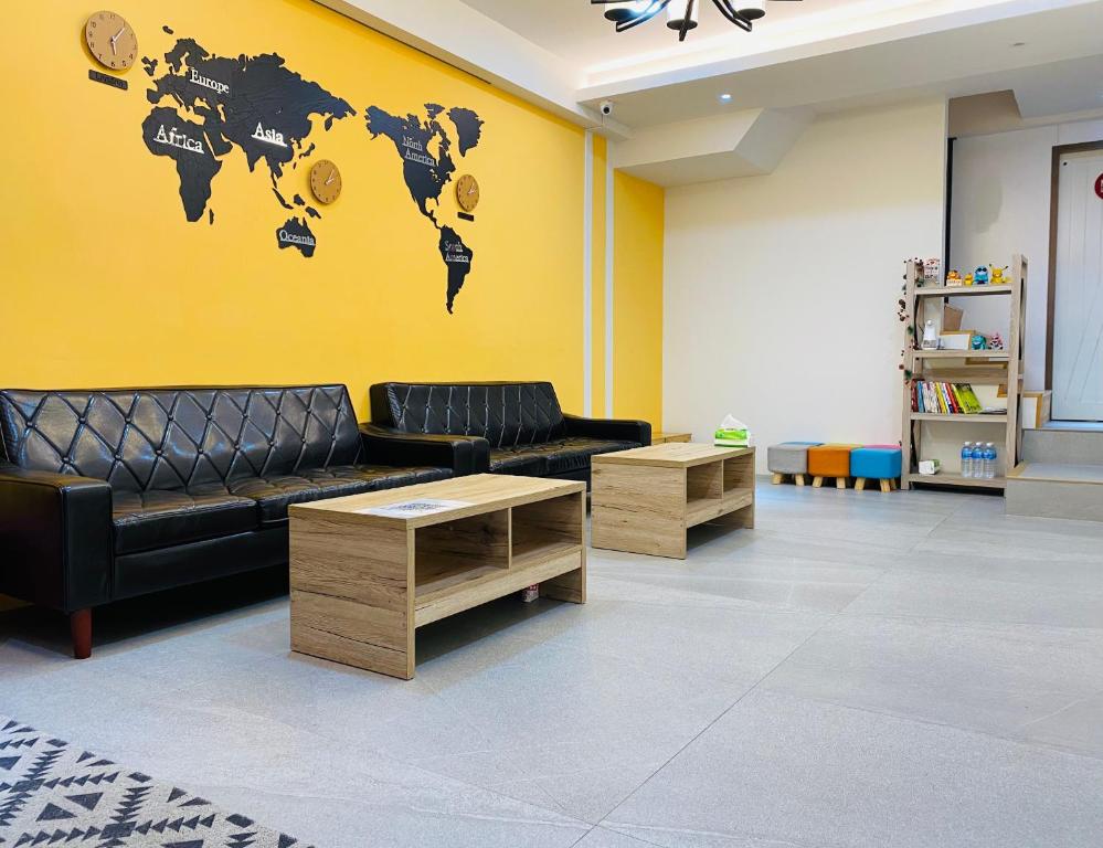 台南吉寓 的客厅配有沙发,墙上挂着世界地图
