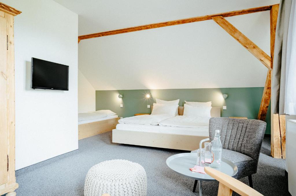 贝里斯泽尔Alpenrose Bayrischzell Hotel的酒店客房配有一张床铺和一张桌子。