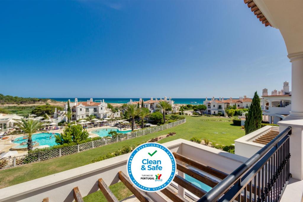 韦尔都勒博邓斯多拉达海滩俱乐部酒店的从度假村的阳台可欣赏到游泳池和海洋的景色