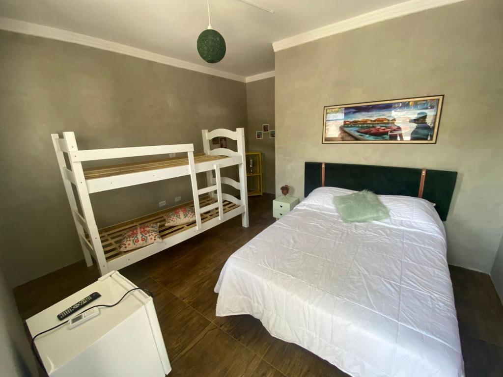 瓜鲁雅Suíte Luxo Refúgio das Ostras的一间卧室配有一张床和两张双层床。