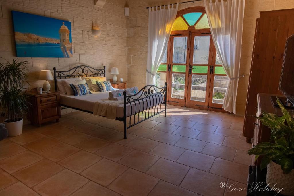 加拉Lellux Qala的一间卧室设有一张床和一个大窗户