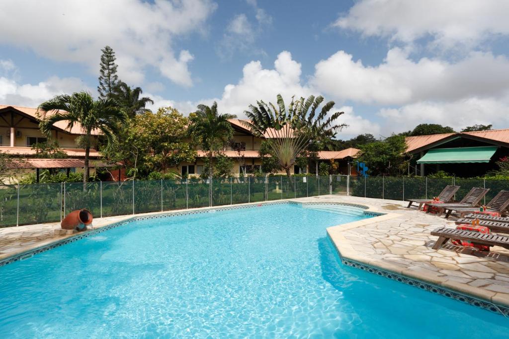 Matoury拉查米耶尔酒店的一个带椅子和围栏的游泳池