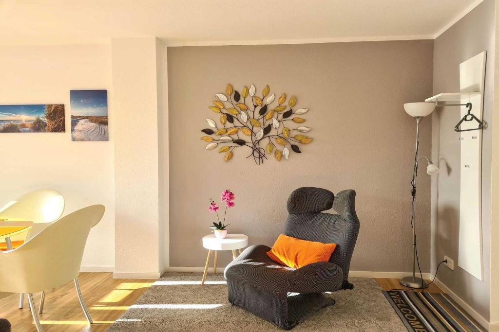 巴贝Villa Stoertebeker Apartment 19的客厅配有带橙色枕头的黑椅