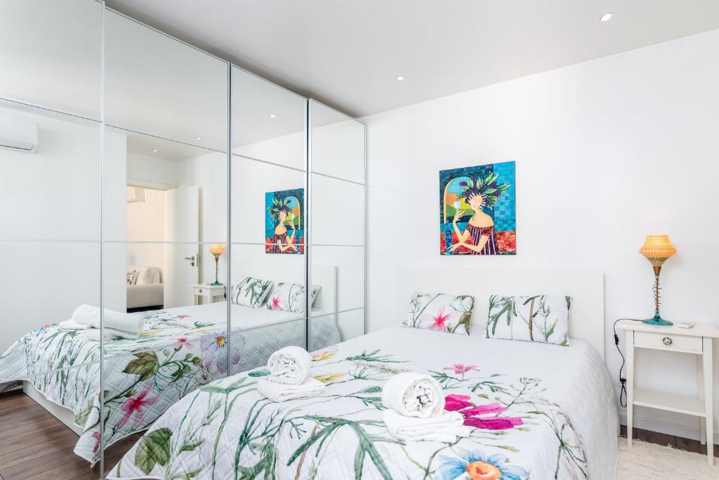埃斯托利尔Tilias Apartment at Estoril的白色卧室设有大型玻璃墙