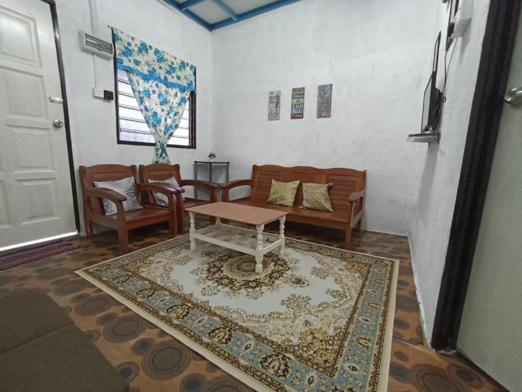 瓜拉弄宾HOME2STAY CHE MAIL 1 KUALA ROMPIN的客厅配有桌子、沙发和地毯。