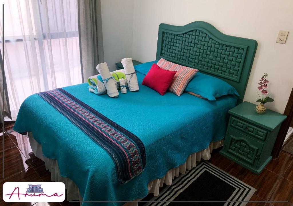 库埃纳瓦卡Aruma Cuernavaca的一间卧室配有蓝色的床和色彩缤纷的枕头