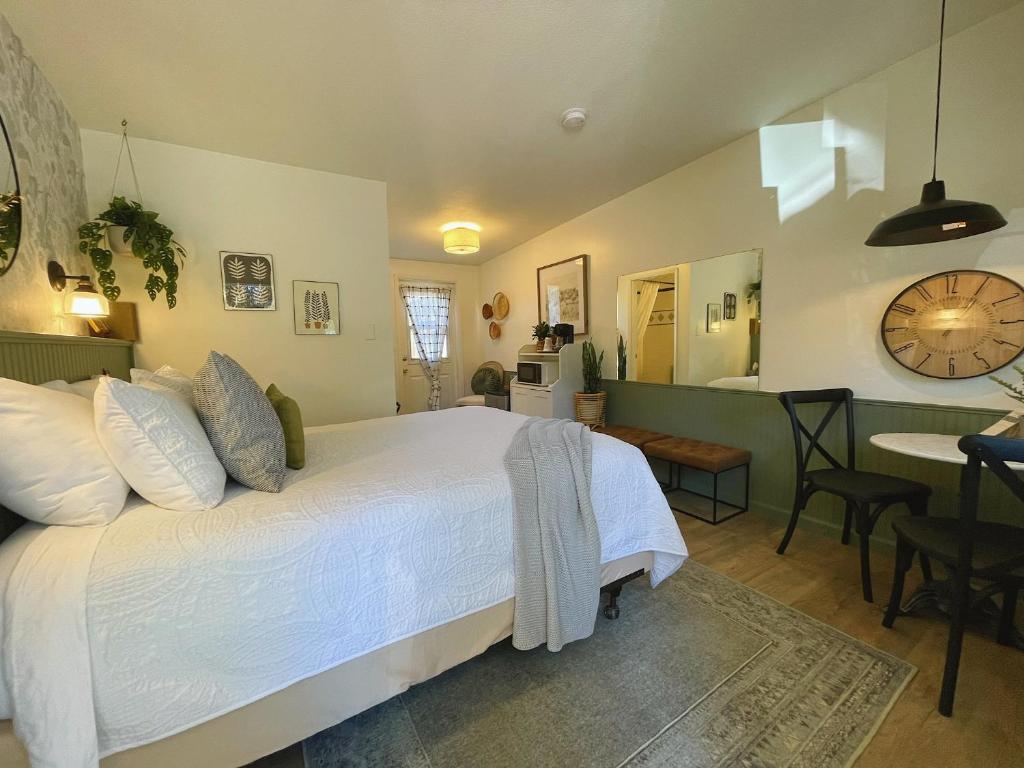 安吉利斯港Emerald Valley Inn的一间带白色大床的卧室和一间厨房