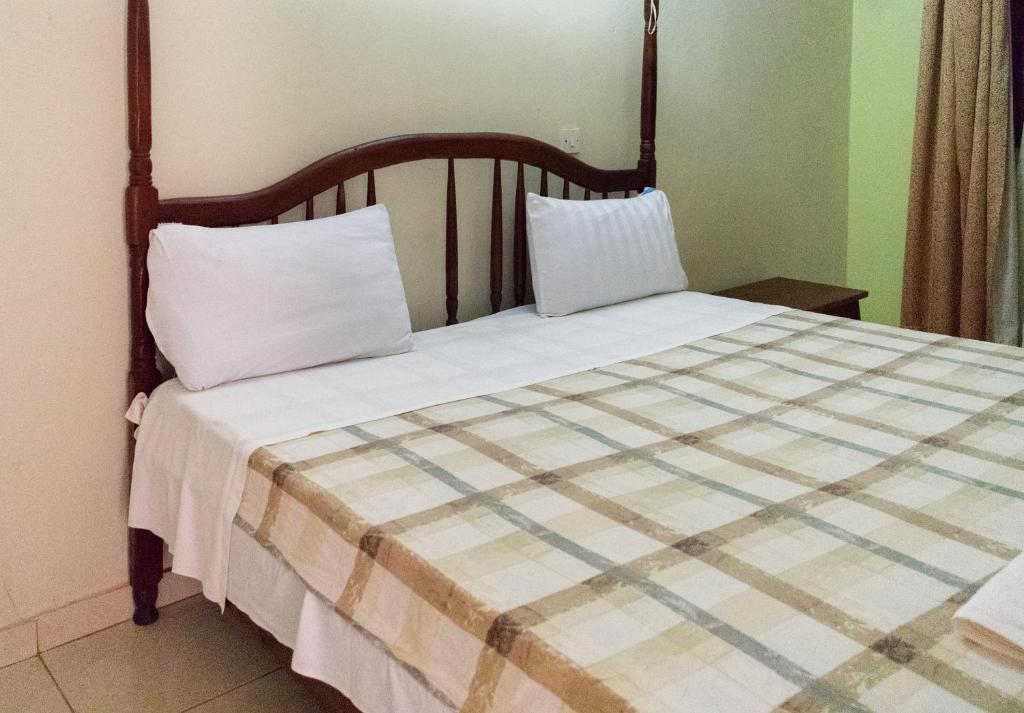 坎帕拉Etana Motel Kampala的一张床上有两个枕头的房间