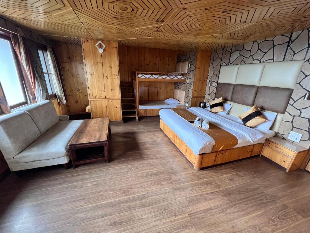 西姆拉Hotel Victory的一间大卧室,配有一张大床和一张沙发