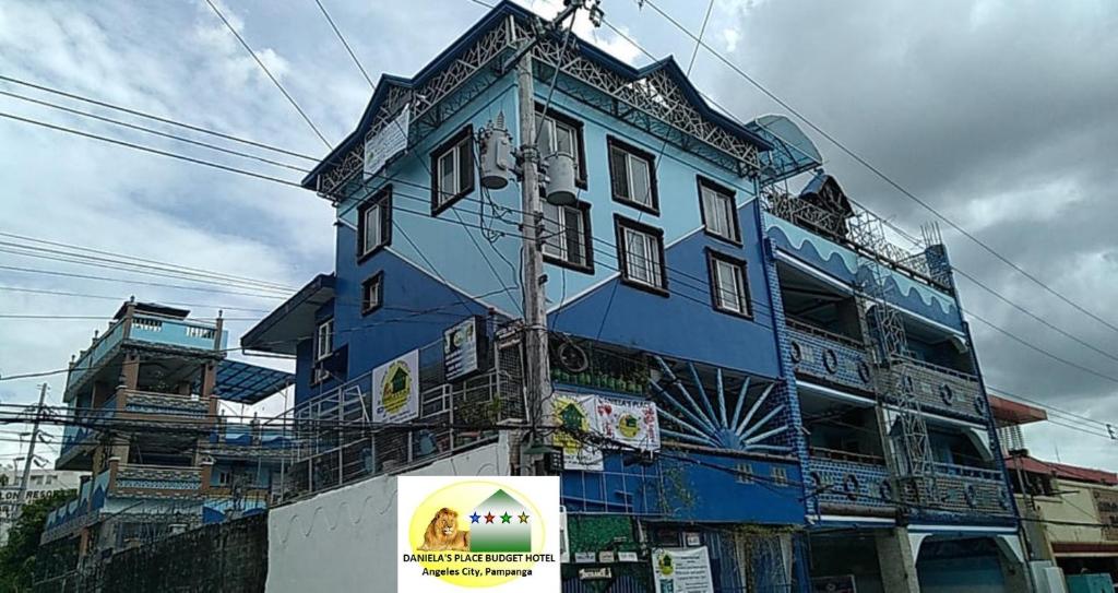 安吉利斯Daniela's Place的蓝色的建筑,前面有标志