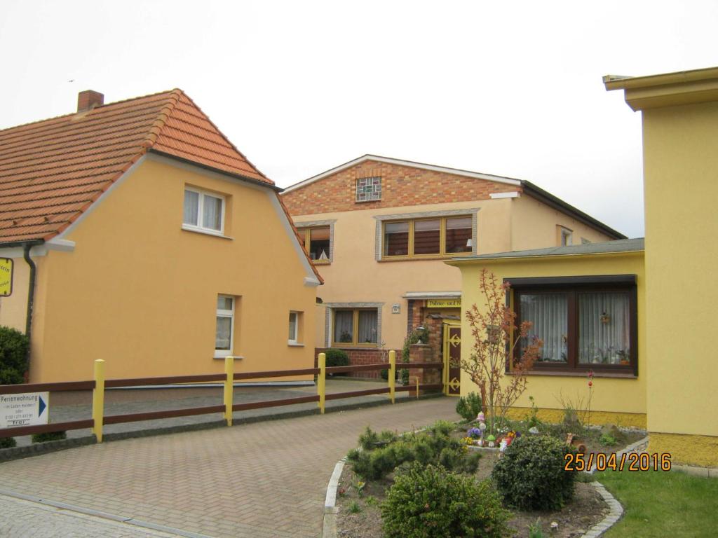 奥斯赛拜-屈隆斯博恩Ferienwohnung Dünensand的前面有栅栏的黄色房子