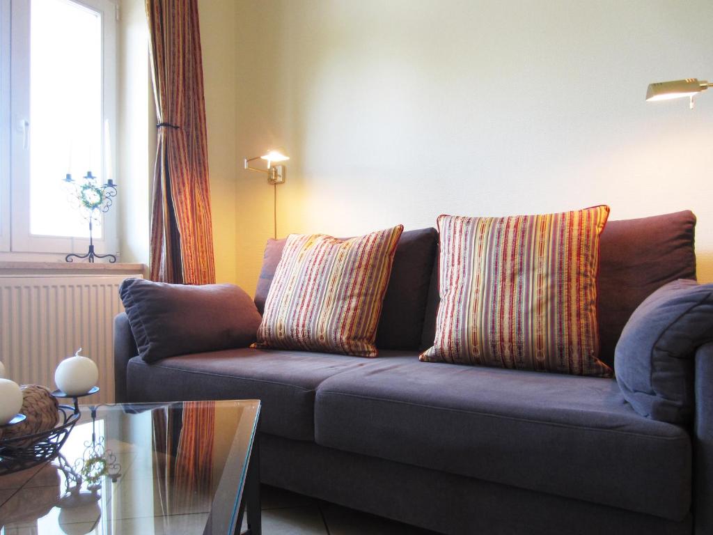 奥斯赛拜-屈隆斯博恩Ferienwohnung Seeadler Nr. 7的客厅配有蓝色沙发和2个枕头