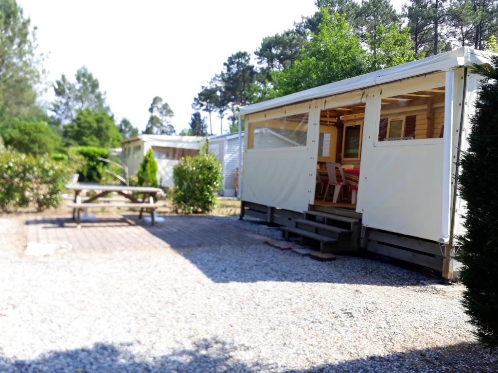 波讷地区圣朱利安Bungalow de 3 chambres avec piscine partagee et jardin amenage a Saint Julien en Born a 5 km de la plage的院子内带野餐桌的小房子