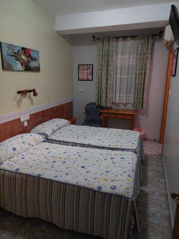 莫特里尔Pensión Colonia的酒店客房,卧室内设有两张床