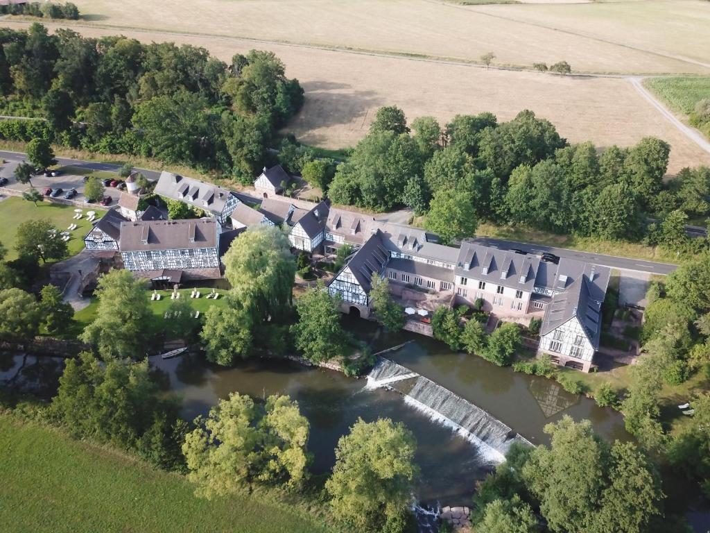 哈默尔堡Neumühle Resort & Spa的享有河流上一座大房子的空中景致